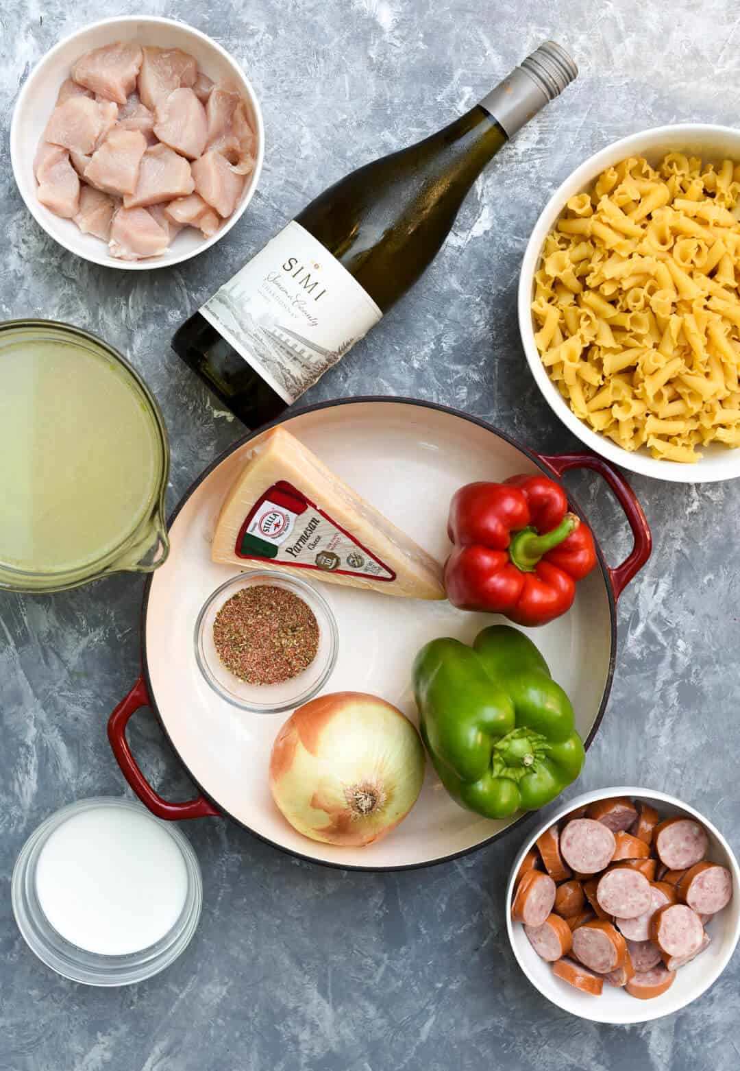 The ingredients for Cheesy Cajun Pasta on a grey surface.