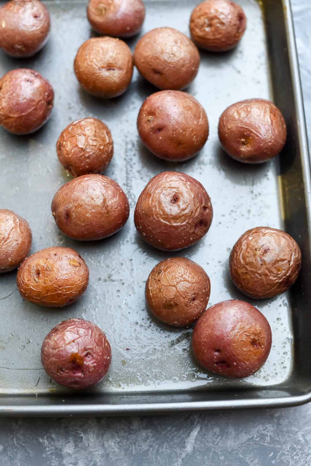 Roasted red potatoes on a rimmed baking sheet.