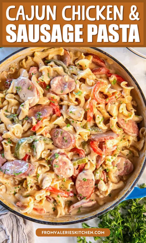 A blue pan filled with creamy Cajun Chicken and Sausage Pasta with text overlay.