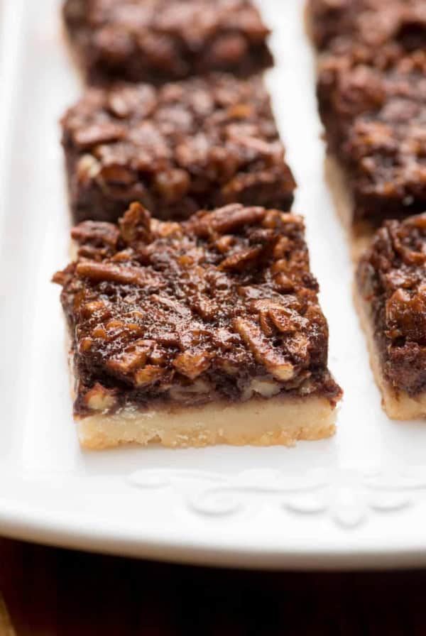 A white platter filled with Chocolate Bourbon Pecan Pie Bars.