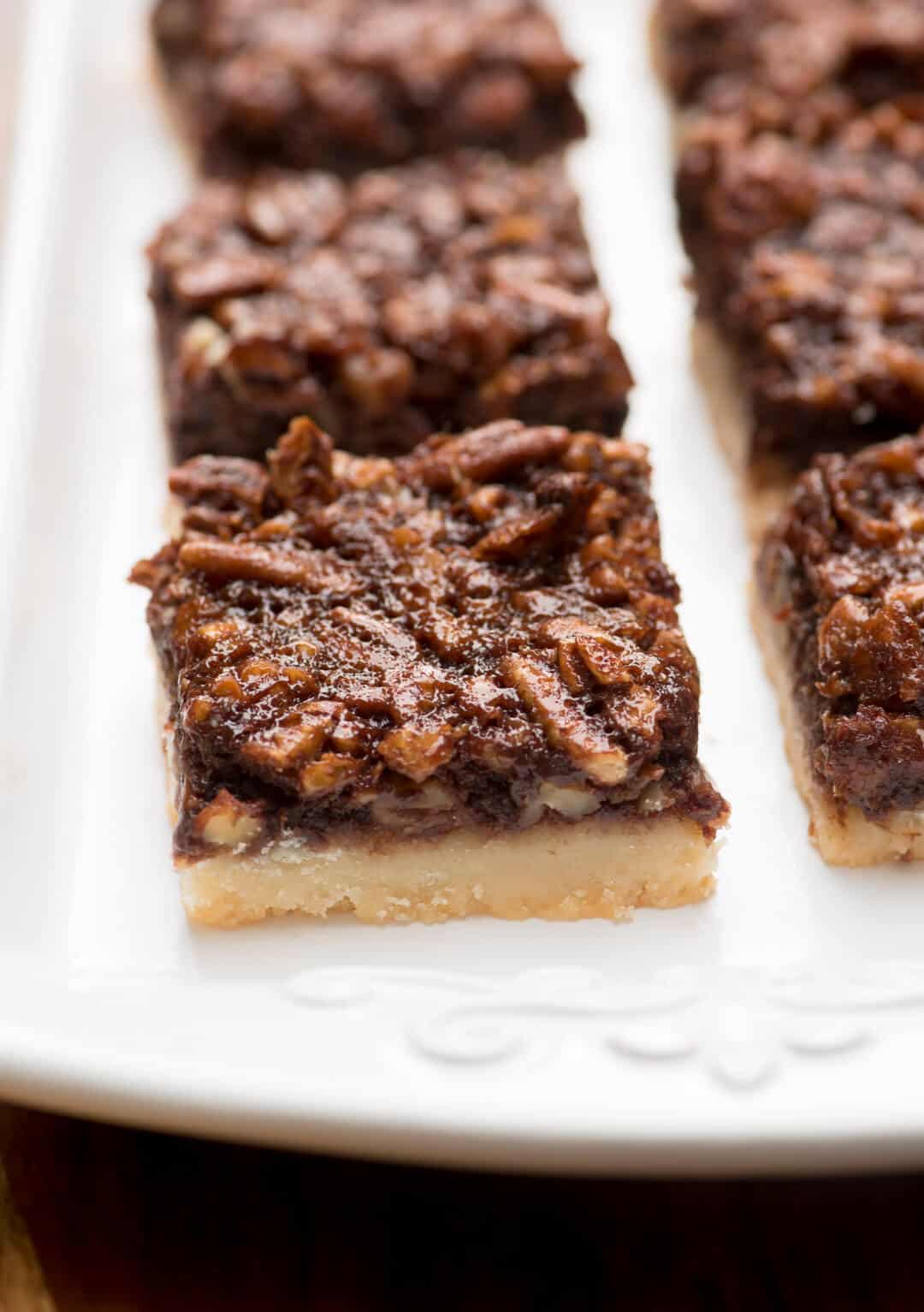 A white platter filled with Chocolate Bourbon Pecan Pie Bars.