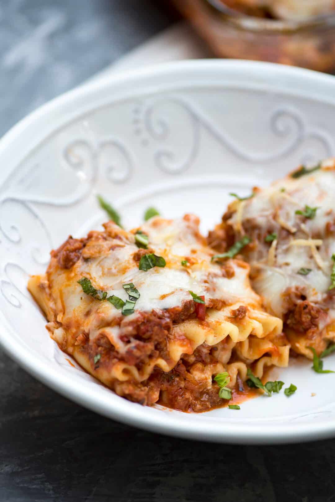 A serving of the lasagna rollups in a white bowl.