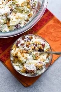 A bowl of fruit salad with whipped cream.