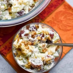 A bowl of fruit salad with whipped cream.