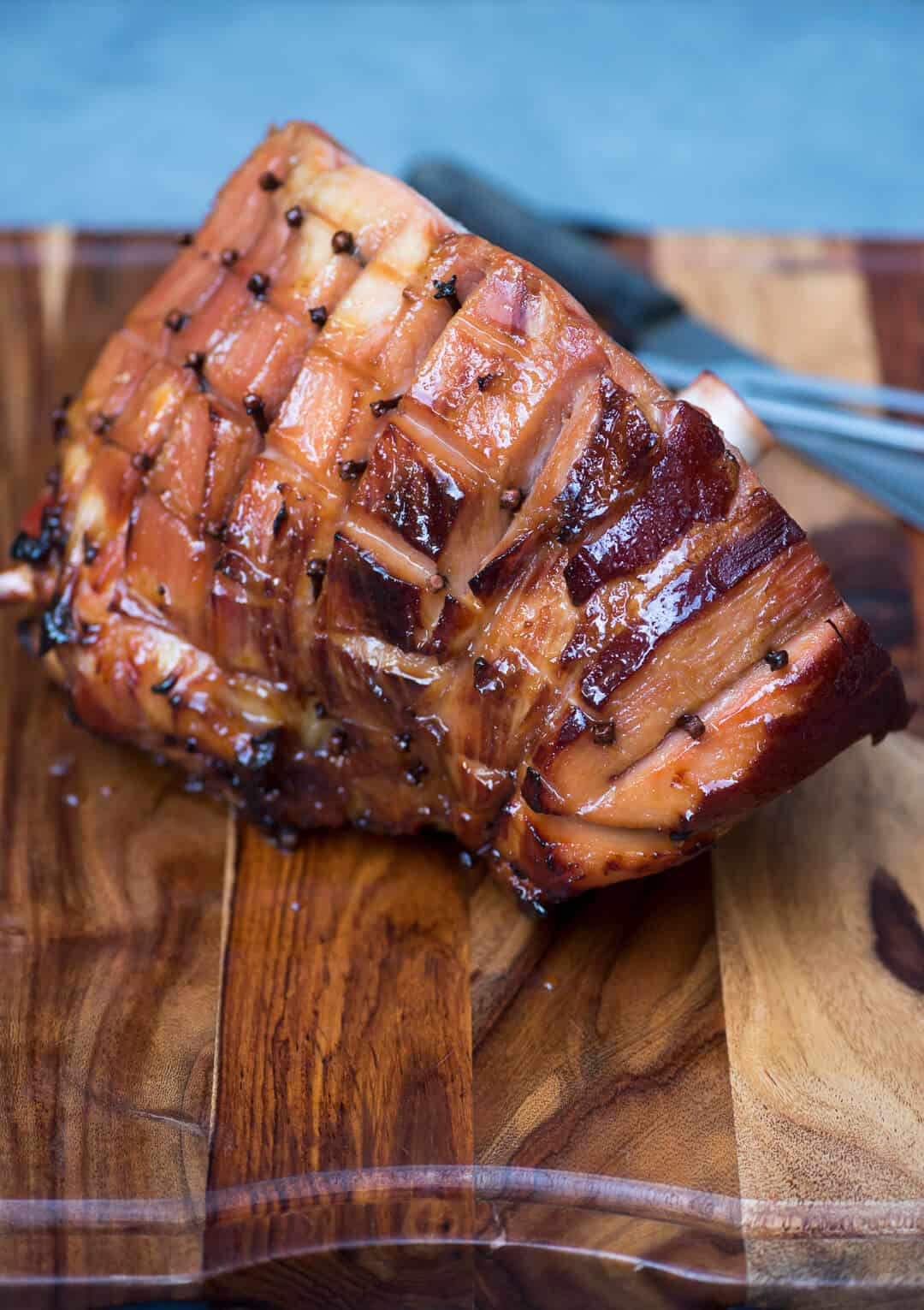 The roasted ham resting on a cutting board.