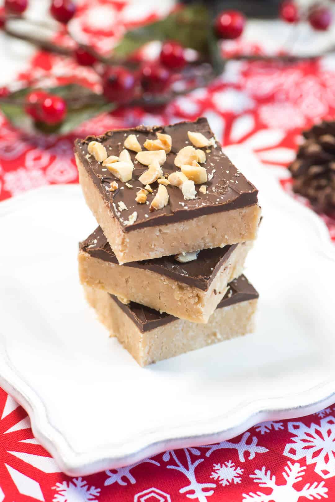 A stack of fudge on a white plate on a red cloth.