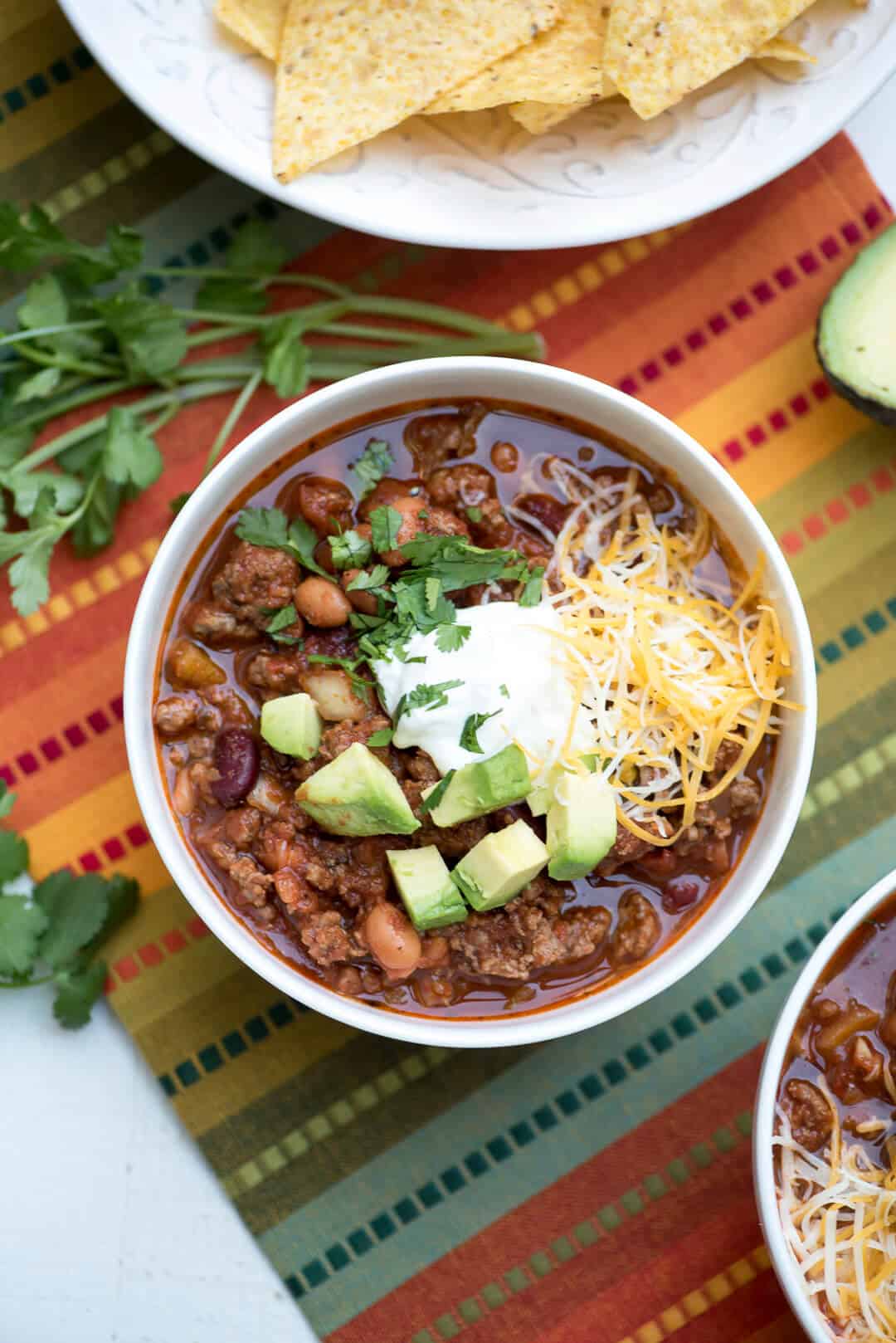 A bowl of Salsa Chili on a colorful cloth shot from over the top.