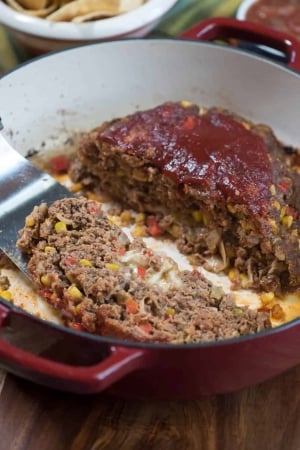 A spatula lifts a slice of meatloaf.