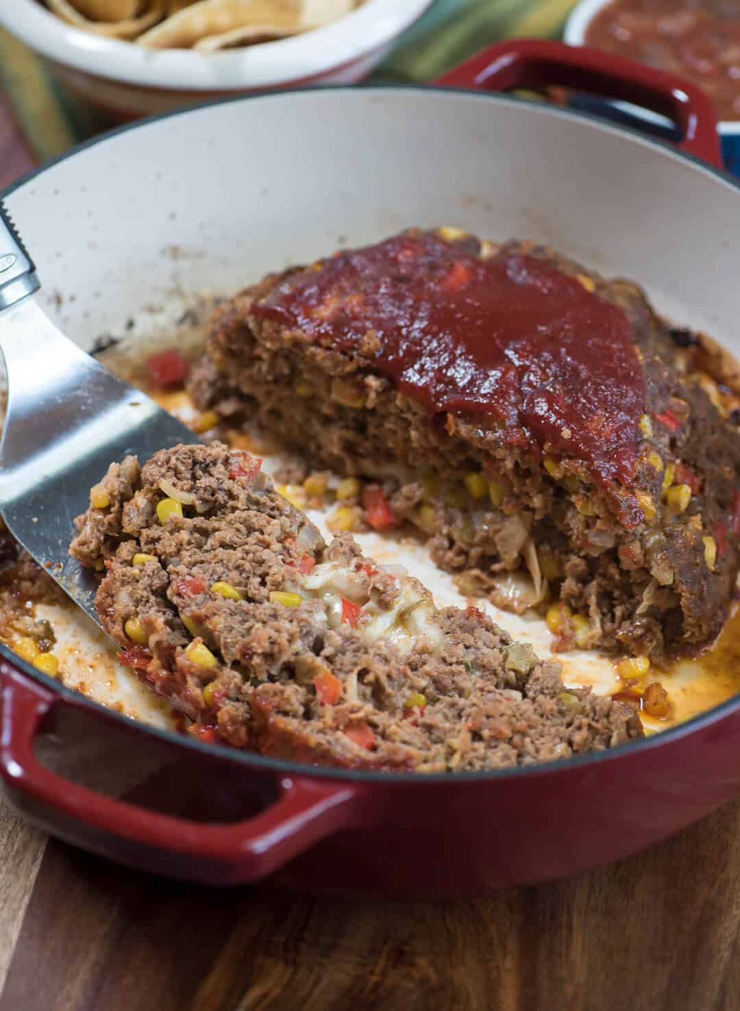 A spatula lifts a slice of meatloaf.
