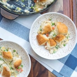 A bowl of chicken pot pie topped with biscuits.