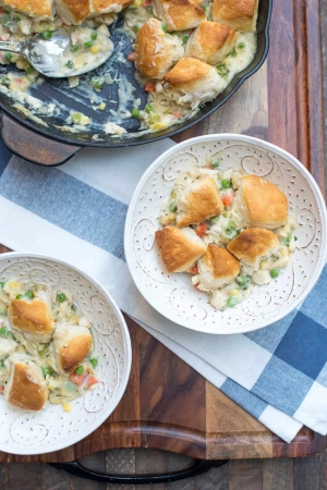 A bowl of chicken pot pie topped with biscuits.
