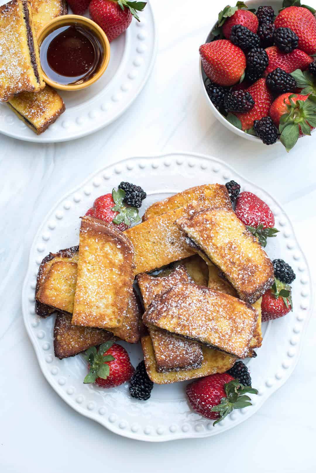 Stacks of Nutella French Toast Sticks with a side of berries.