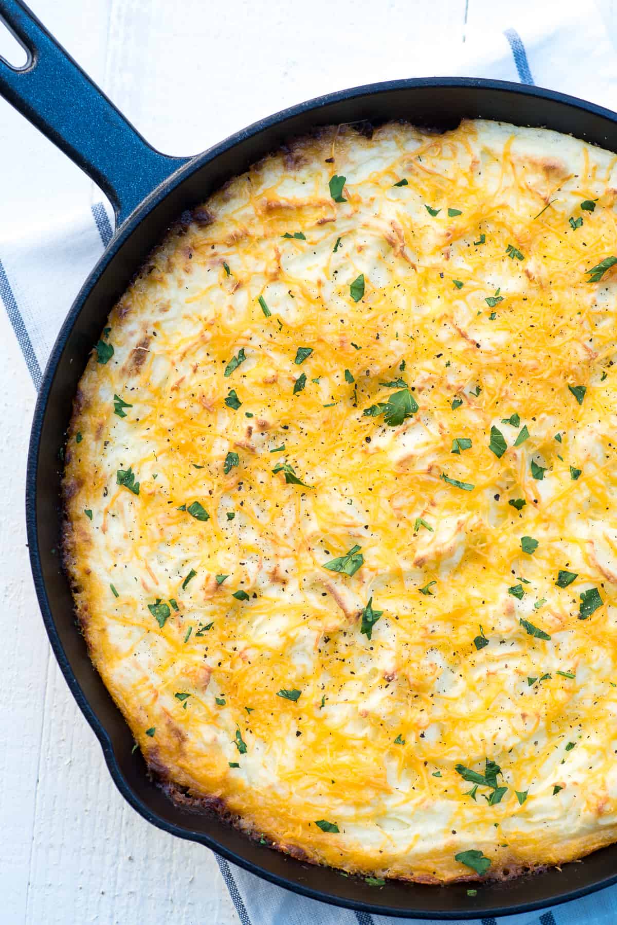 Skillet sheperd's pie topped with mashed potatoes in a cast iron skillet.