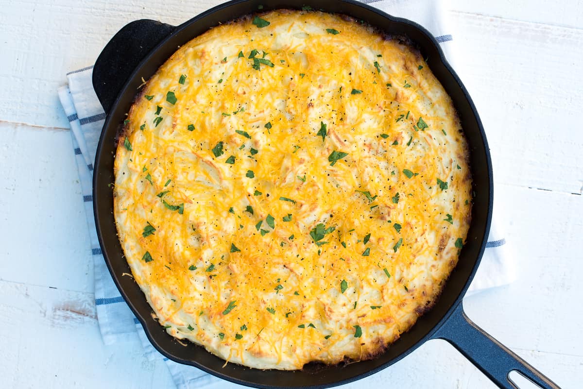 Skillet sheperd's pie topped with mashed potatoes in a cast iron skillet.