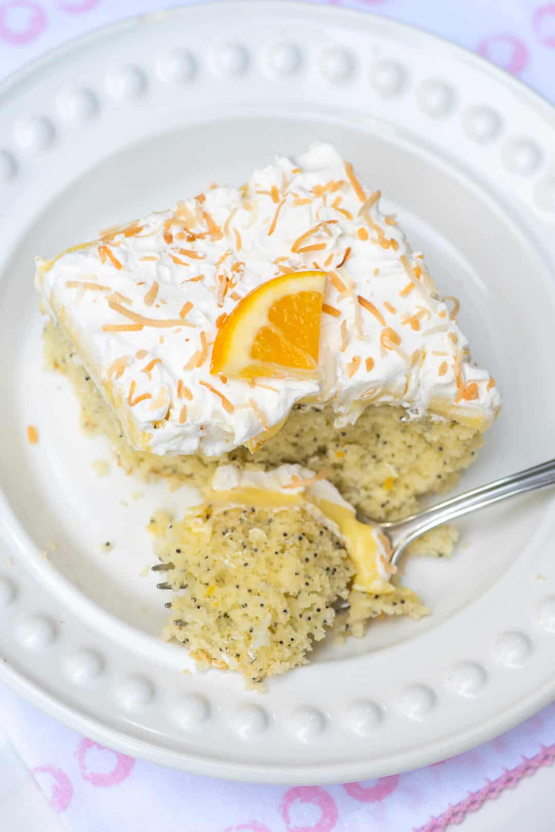 An over the top image of the piece of lemon poppy seed cake with a fork breaking into it.