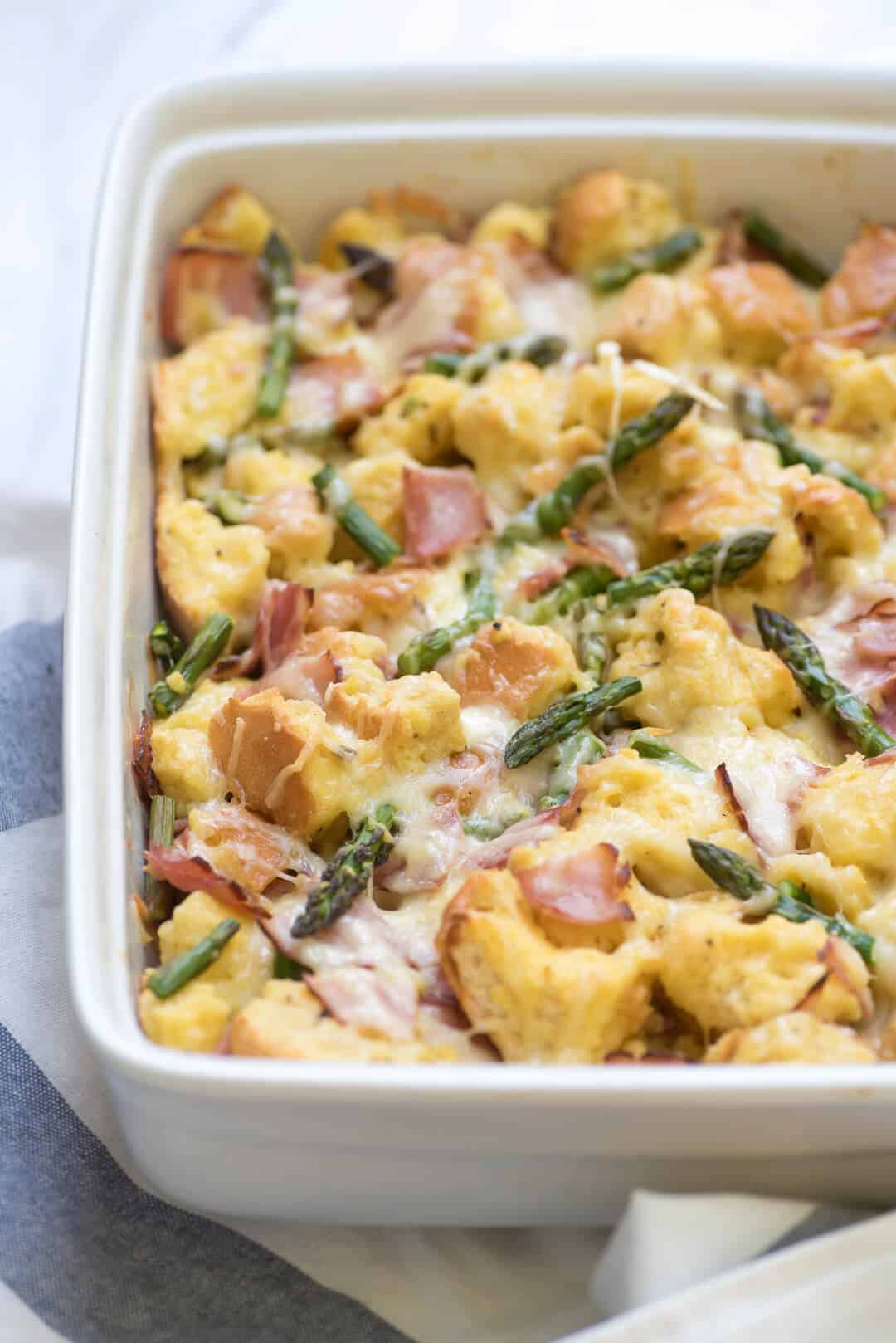 Savory French Toast Bake in a white casserole dish on a blue and white striped cloth.