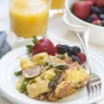 A plate with a serving of french toast bake and fruit.