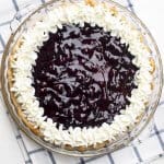 Blueberry Lemon Sour Cream Pie decorated with whipped cream around the edges.