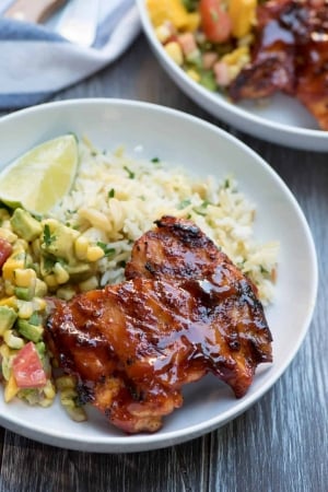 Glazed chicken with rice in a white bowl.