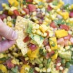 Mango Avocado Corn Salsa on a tortilla chip.