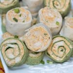 Tortilla rollups on a white platter.