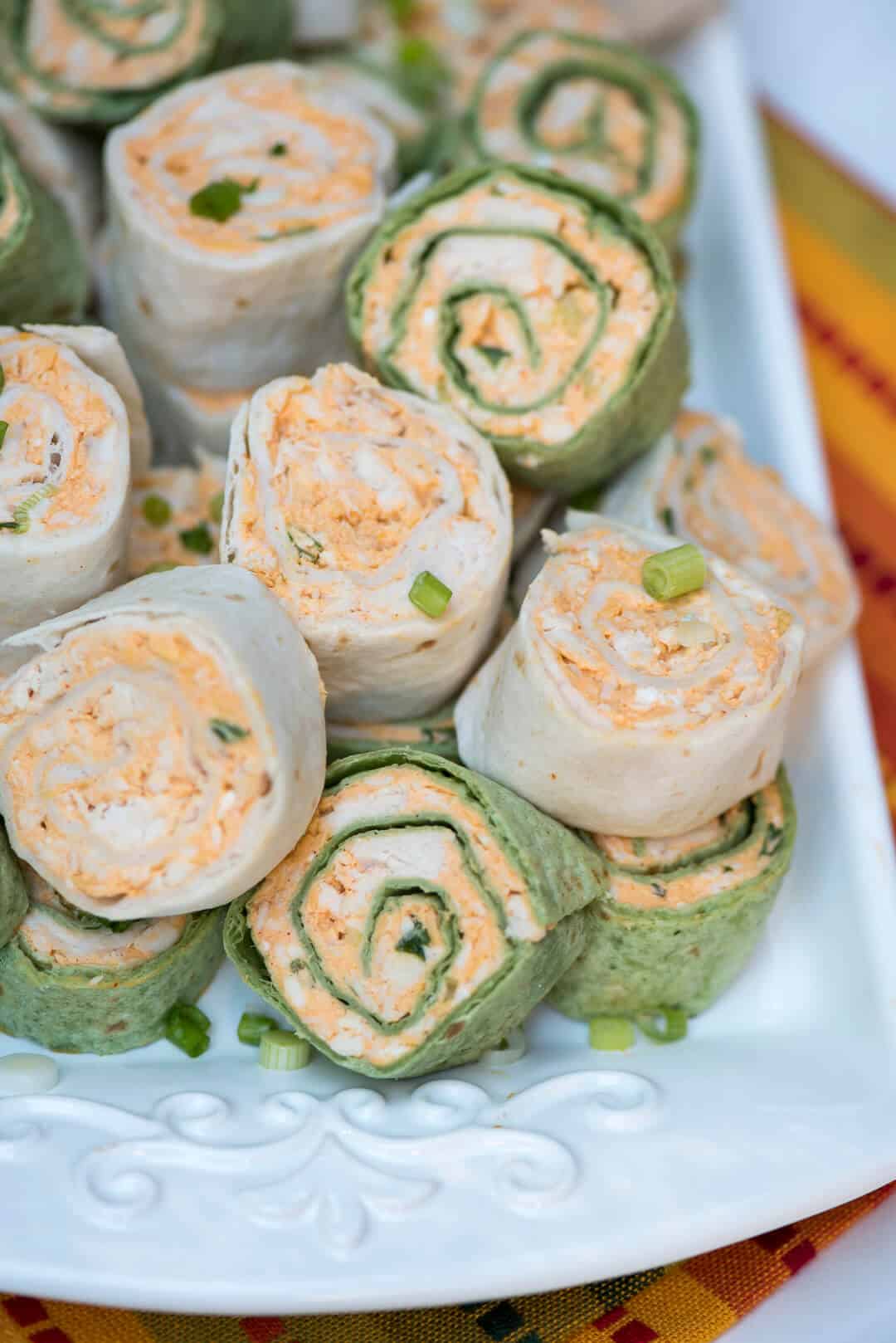 A close up shot of the pinwheels on a white serving tray.