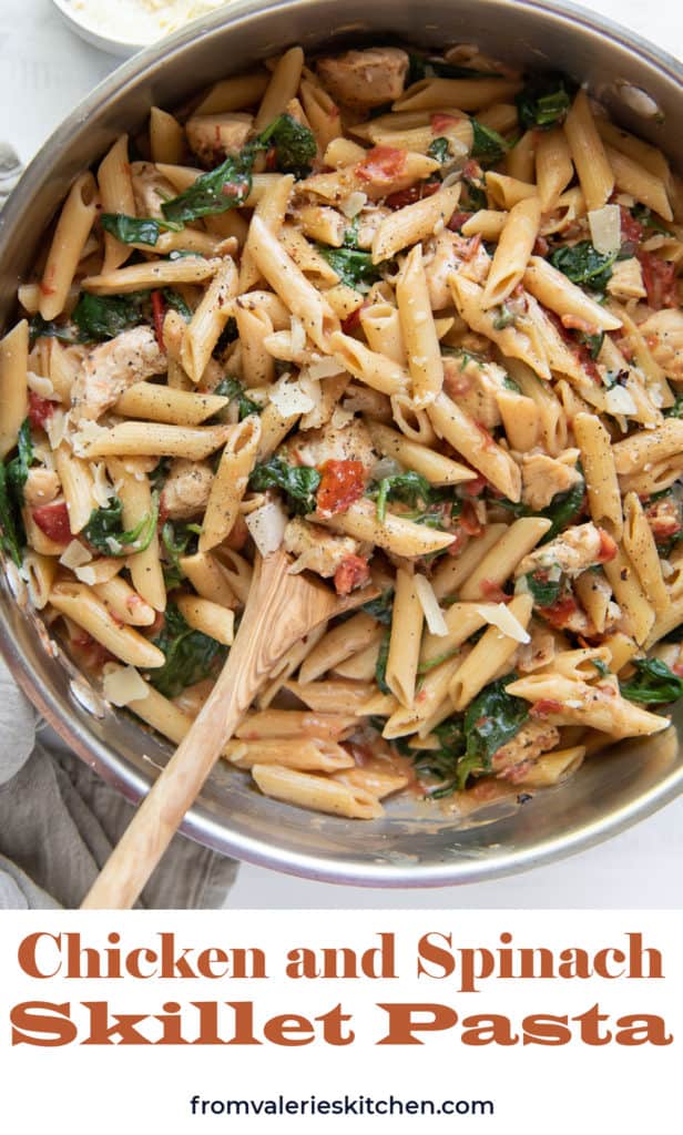 A top down shot of pasta with chicken and spinach in a skillet with a wooden spoon with text overlay.