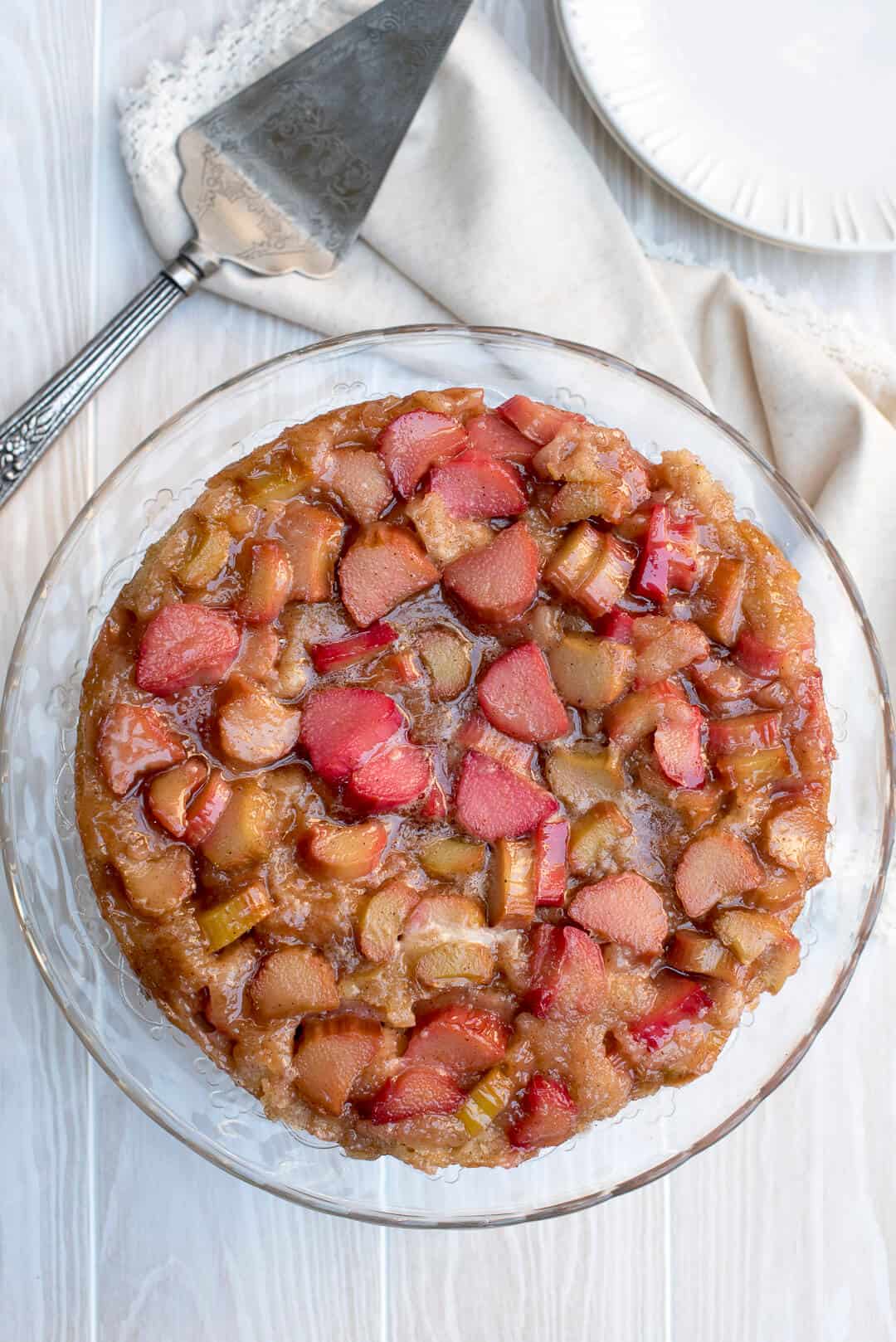 An over the top image of Rhubarb Upside Down Cake on a glass cake plate.