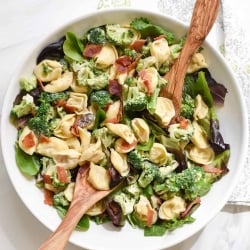 A bowl of tortellini, broccoli, and spinach.