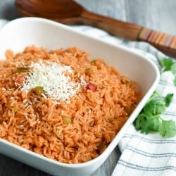 A bowl of rice topped with shredded white cheese.