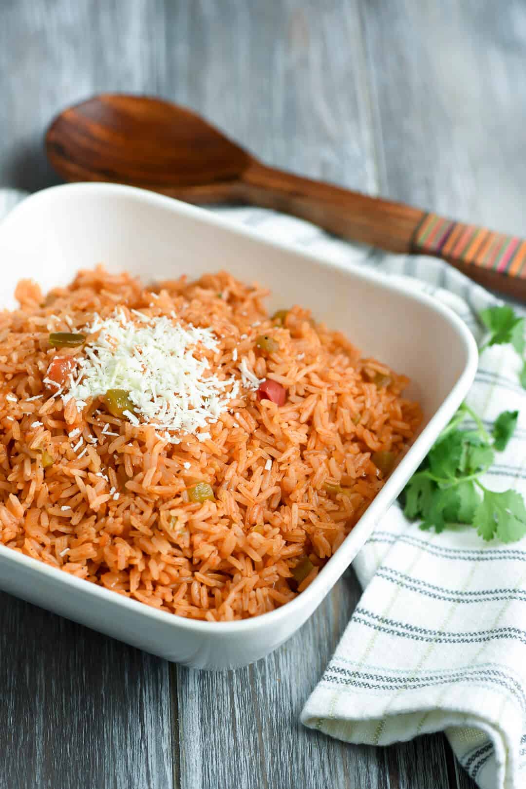 A bowl of rice topped with shredded white cheese.