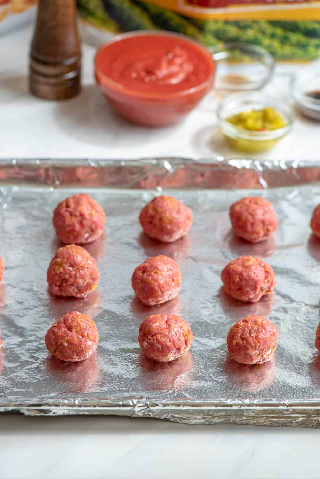 The meat mixture is formed into balls and placed on a foil lined baking sheet.