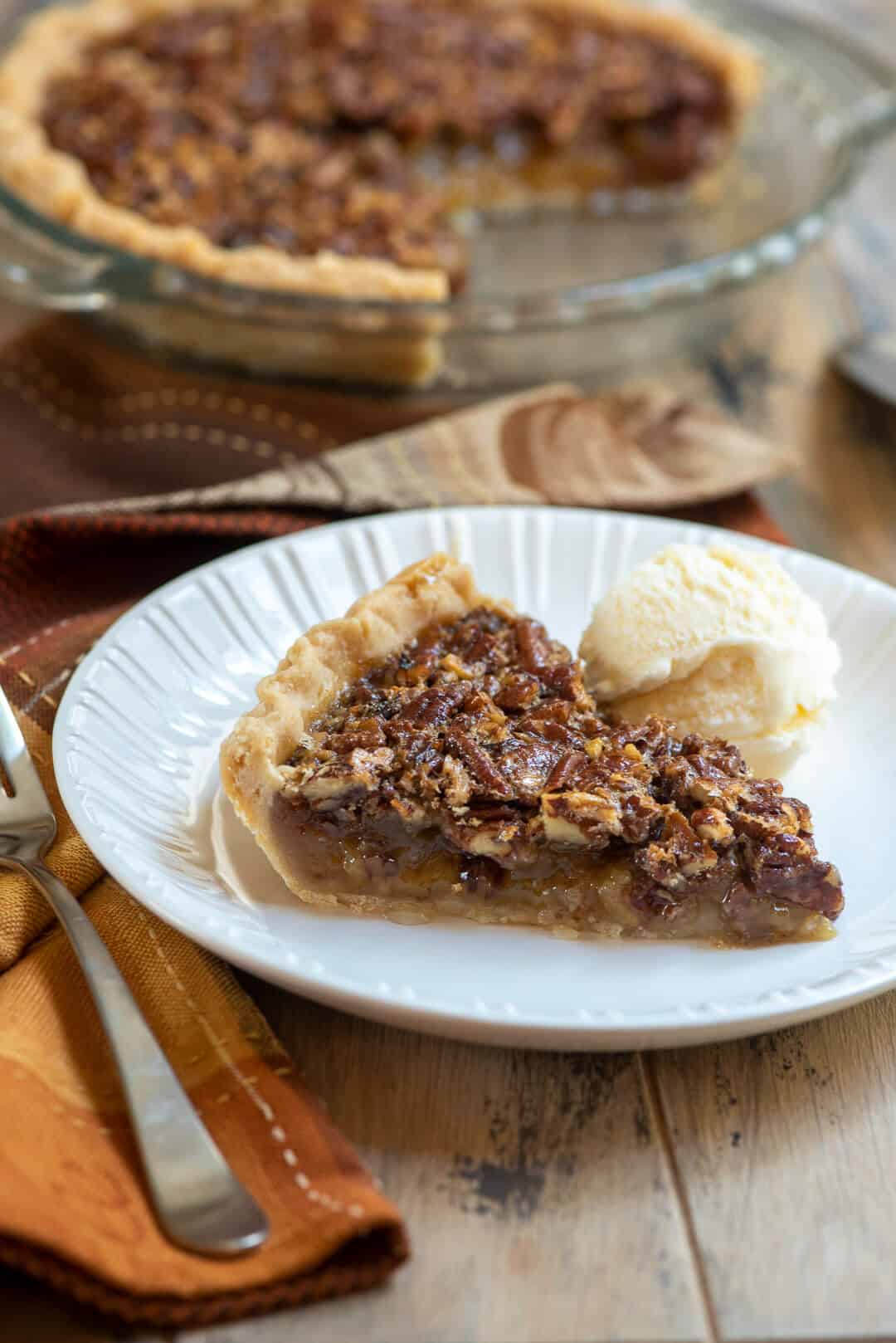 A slice of pie on a plate with ice cream.