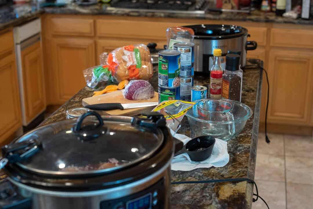 Valerie's messy kitchen counter full of ingredients and two slow cookers.