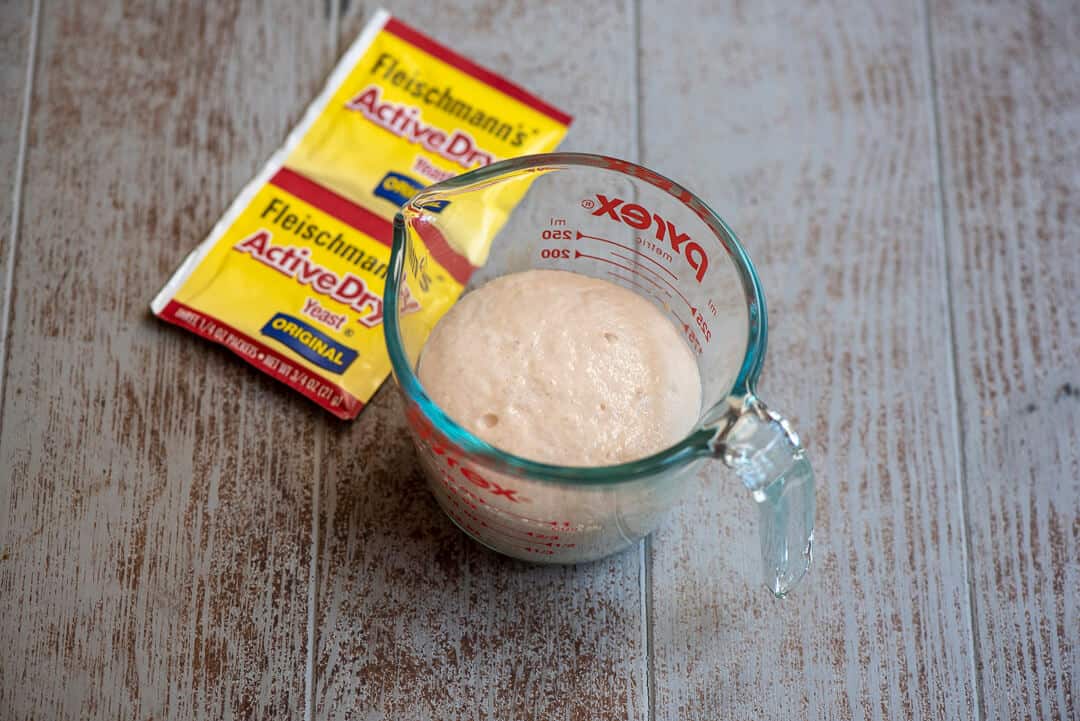 A measuring cup with proofed yeast.