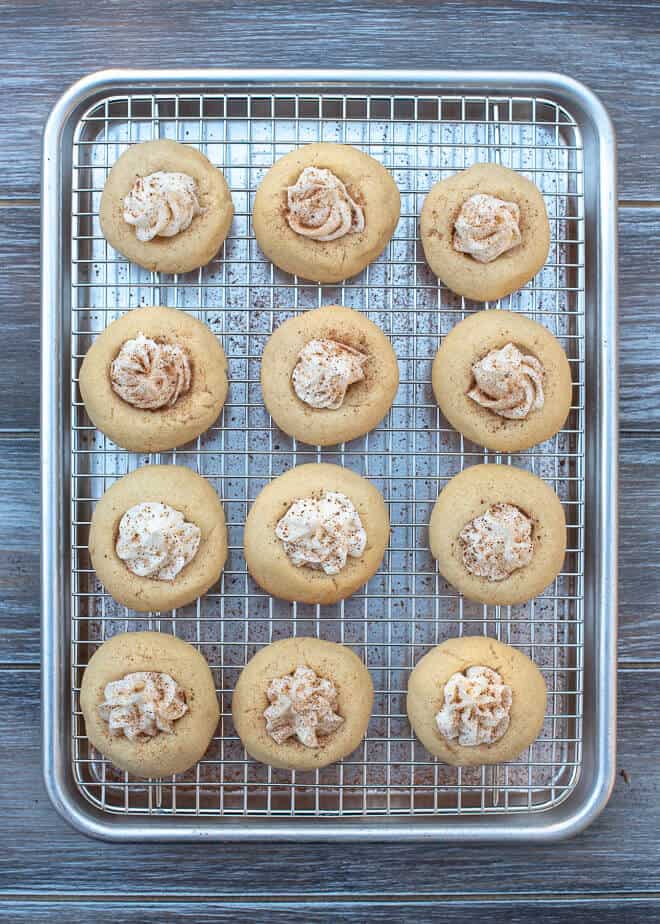 The cookies on a wire rack and sprinkled with nutmeg.