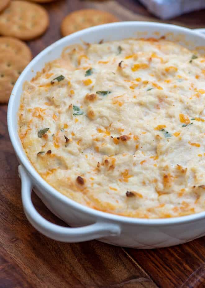 A close up shot of the Cheesy Hot Crab Dip in a white serving dish.
