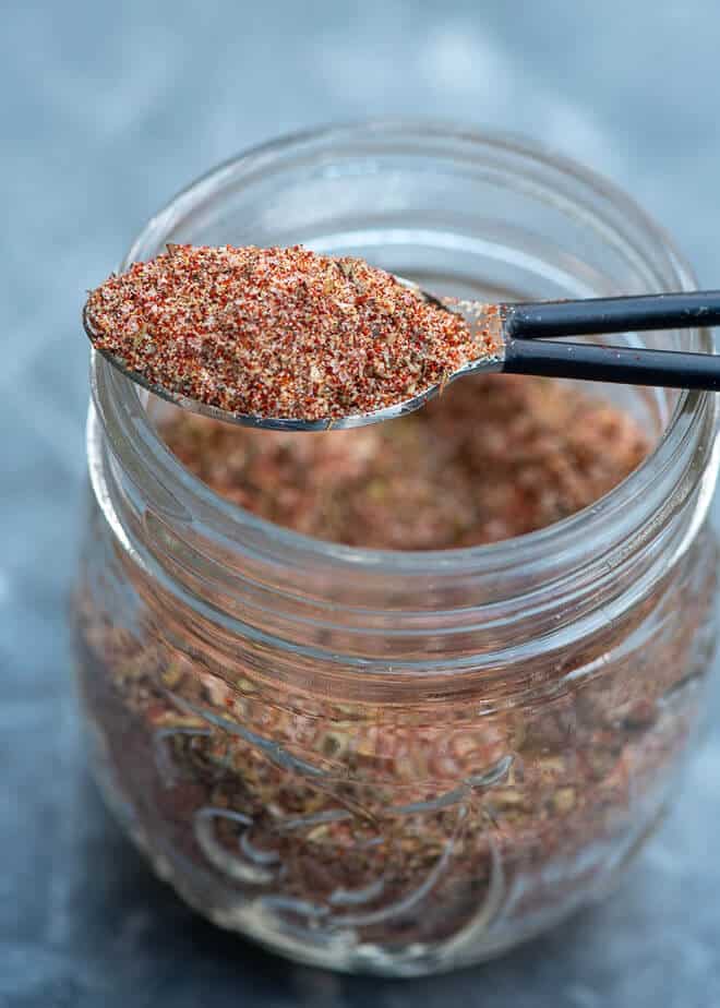 An image shot from the side shows a small spoonful of the seasoning mix after it is scooped from the mason jar.