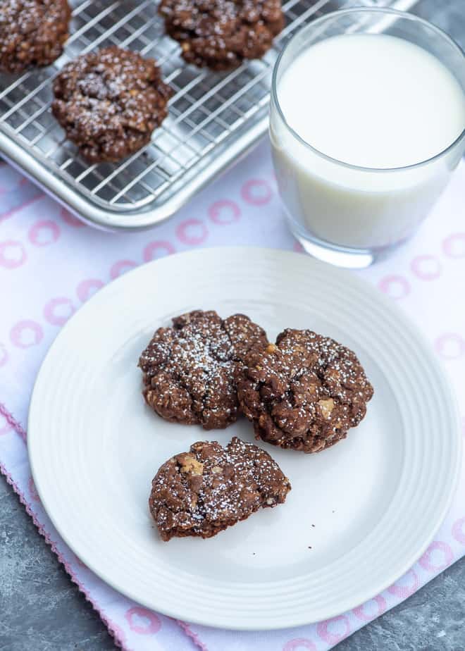 Chocolate Brownie Oatmeal Cookies on a small white plate with a glass of milk