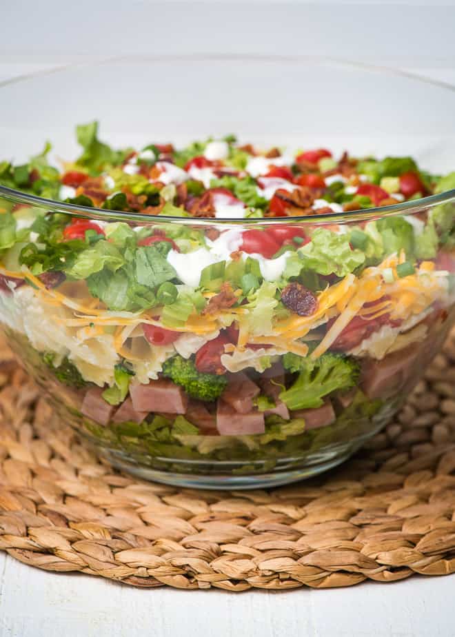 Layered Ham and Broccoli Pasta Salad in a clear glass bowl from the side.