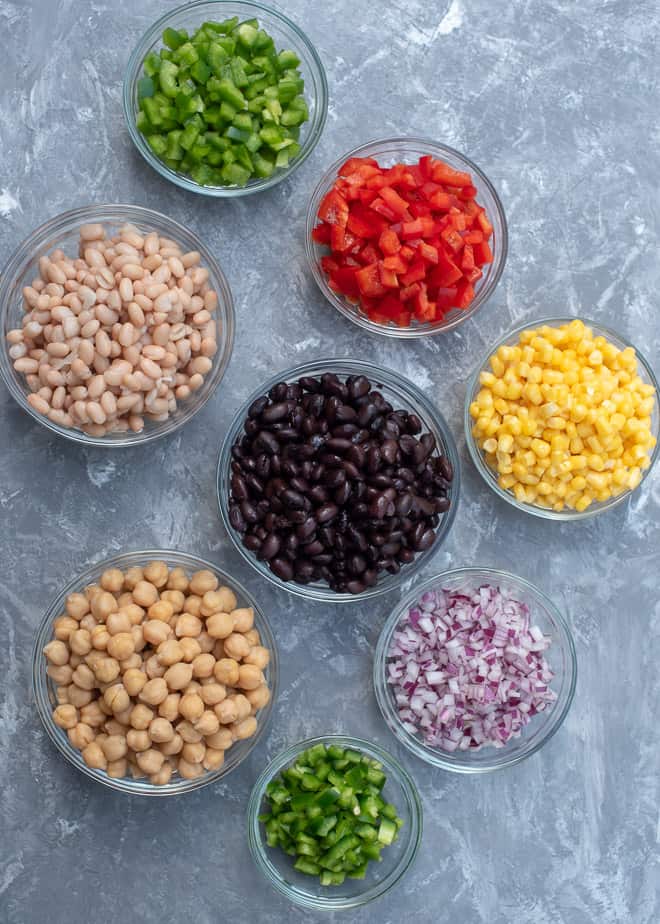 Beans, peppers, corn and red onion in small glass bowls.