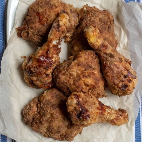 Pieces of fried chicken on parchment paper.