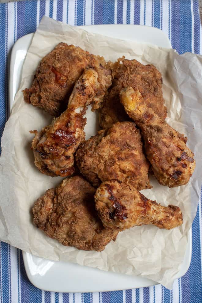 Pieces of fried chicken on parchment paper.