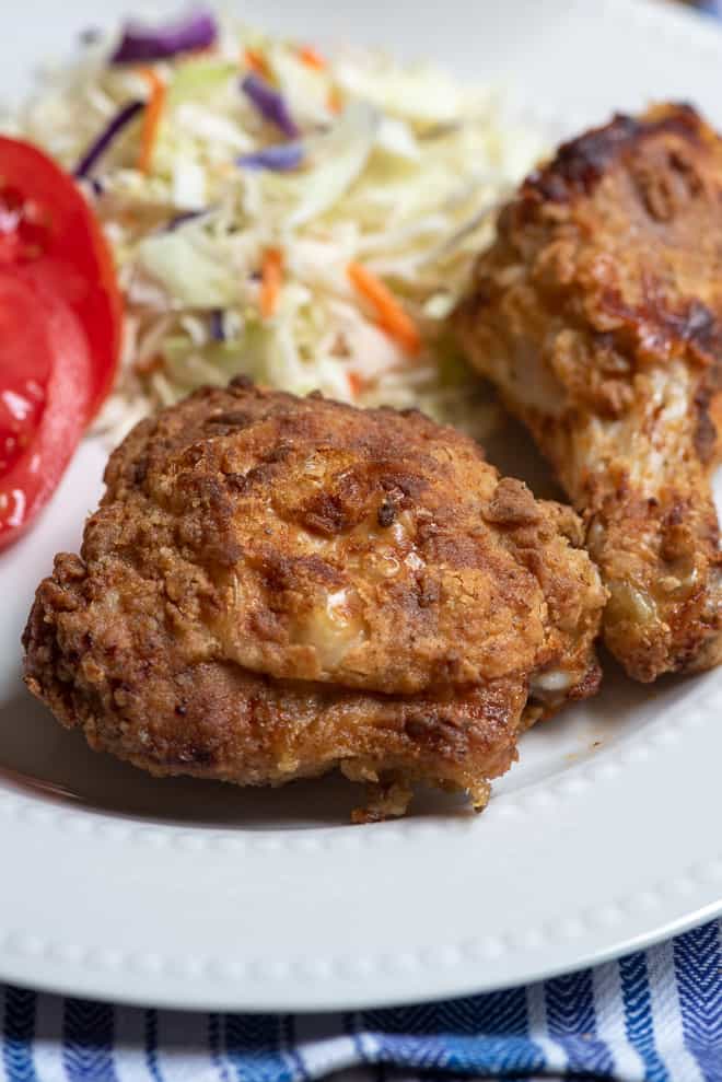 A close up image of Air Fryer Fried Chicken on a white serving plate.