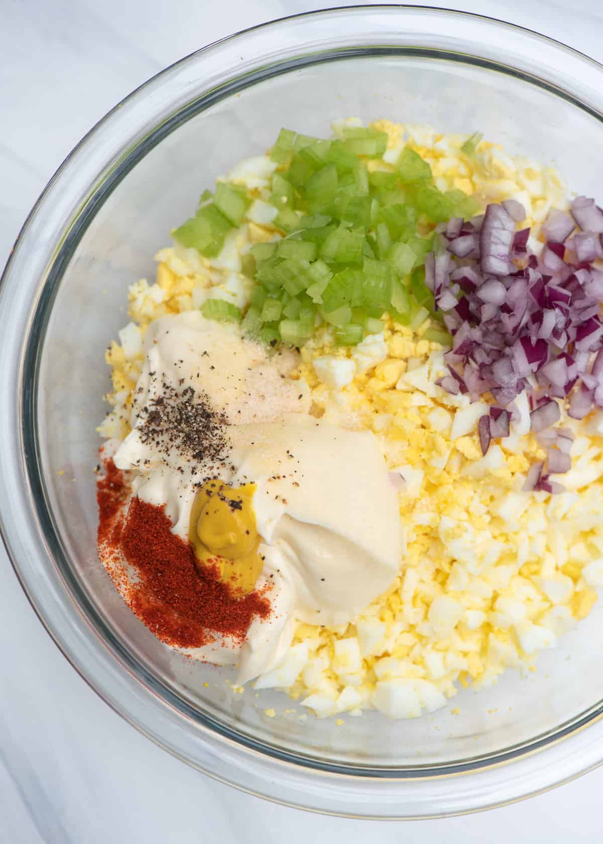 The ingredients for egg salad in a mixing bowl.