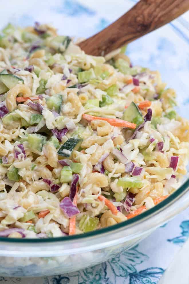 A close up image of Macaroni Coleslaw in a glass serving bowl.