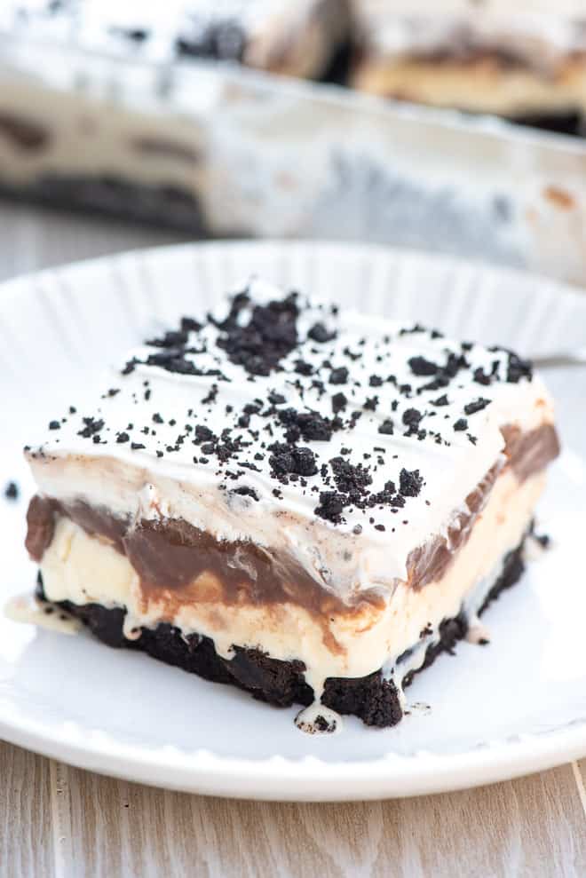 A slice of Buster Bar Ice Cream Dessert on a white serving plate.