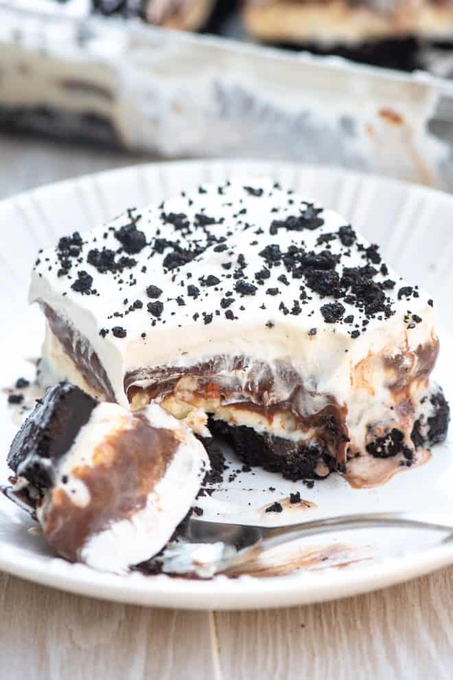 A slice of the dessert on a white plate broken into with a fork.