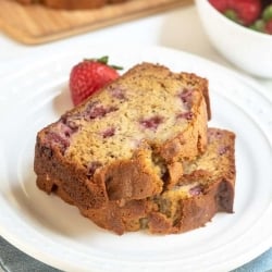 Two pieces of strawberry banana bread stacked on a white plate.