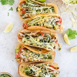 Tacos topped with cabbage and corn.